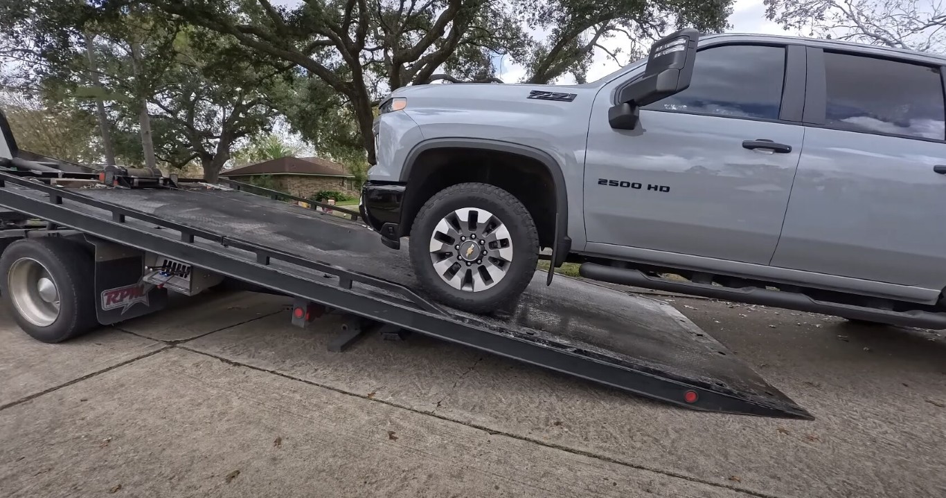 Flatbed tow truck loading a Chevrolet Silverado 2500 HD in North Babylon, NY